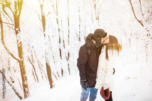 Happy young couple having fun in the winter park photo