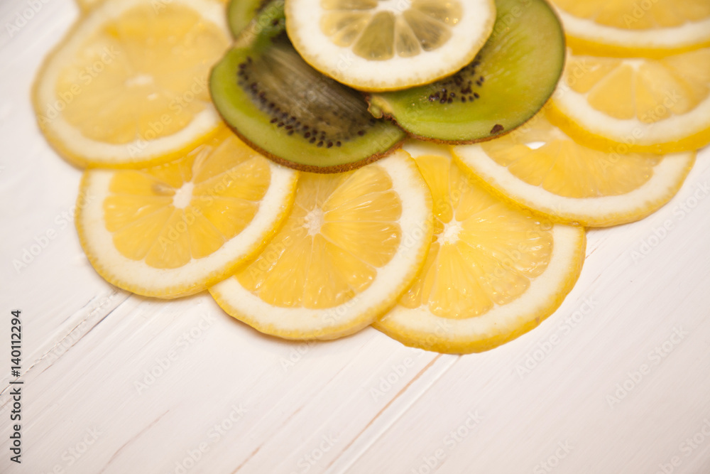 Pieces of kiwi and lemon on a wooden background Pieces of kiwi and lemon on a wooden background