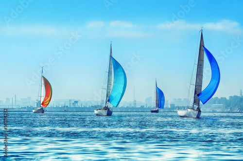 Sailing boats on the river, the reflection on water in the distance shore.