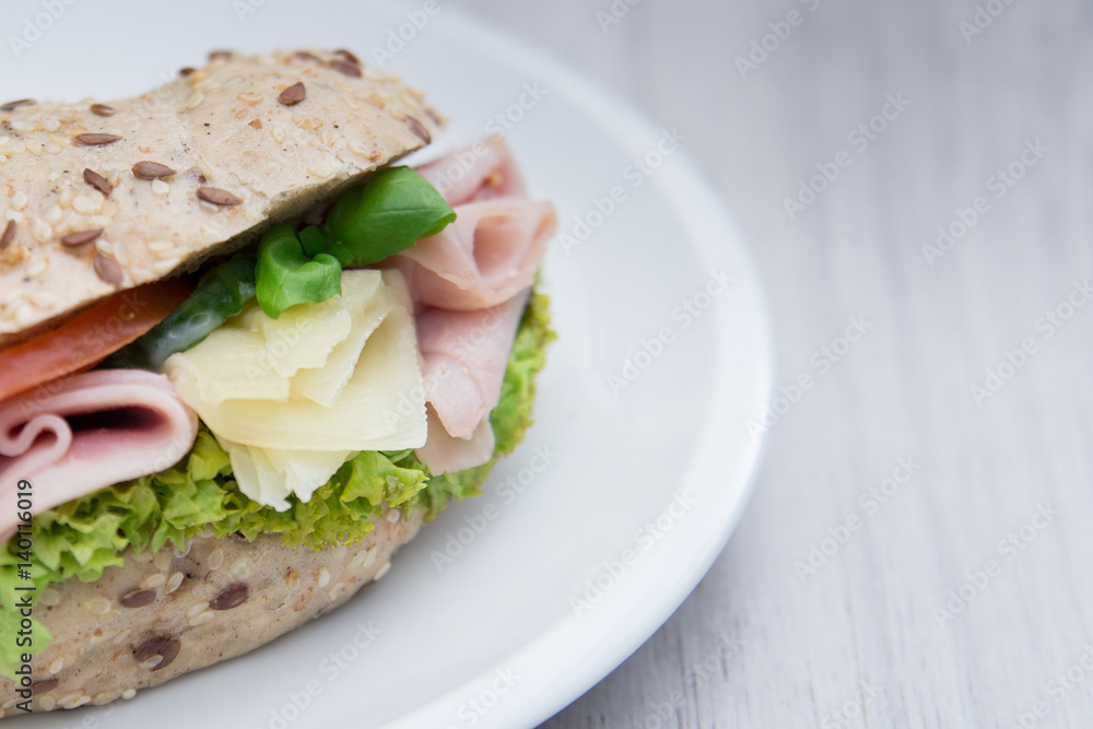 Baguette sandwich with ham, cheese, tomatoes and lettuce. Close up Baguette sandwich with ham, cheese, tomatoes and lettuce. Close up