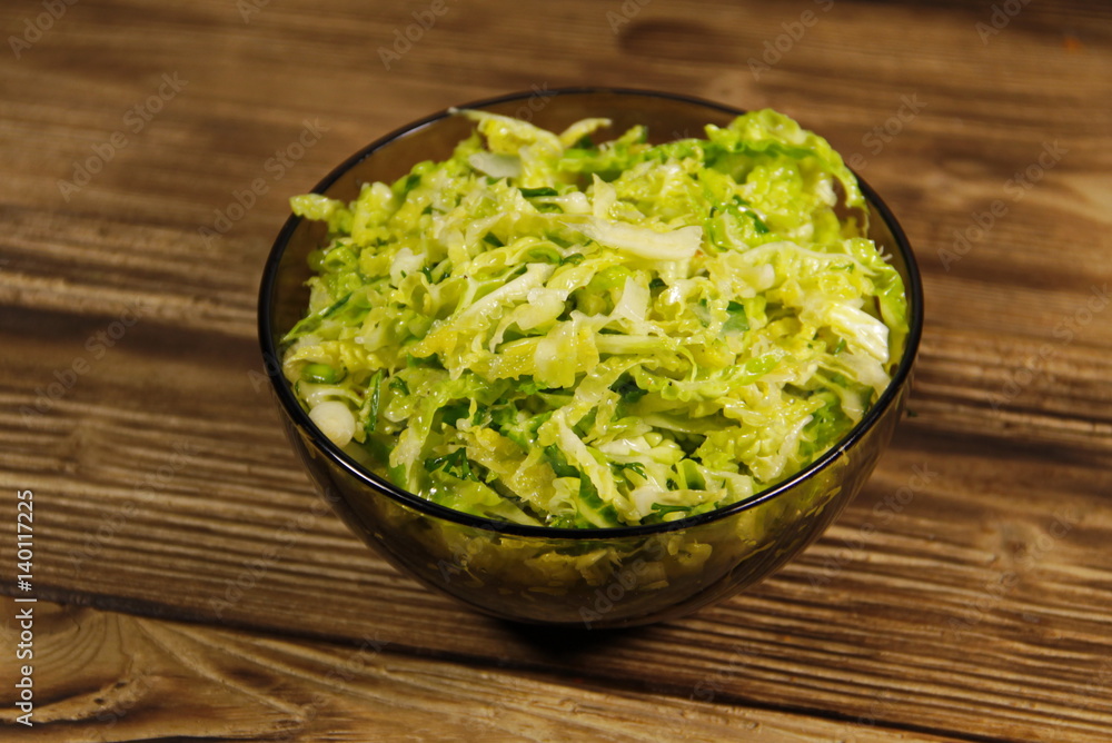 Savoy cabbage salad in glass bowl on wooden table Savoy cabbage salad in glass bowl on wooden table