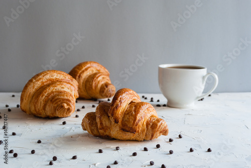 Croissant with coffee for breakfast. Chocolate crumbs.