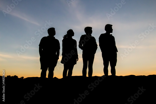 Silhouette of people posting during sunset