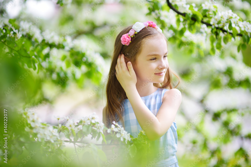 Adorable little girl in blooming apple tree garden on beautiful spring day Adorable little girl in blooming apple tree garden on beautiful spring day
