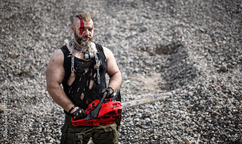 man with a red chainsaw is attacking photo