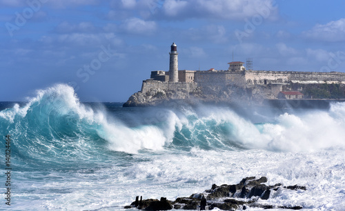 Waves breaking near the Malecon with Morro Castle in the background, Havana, Cuba © akturer