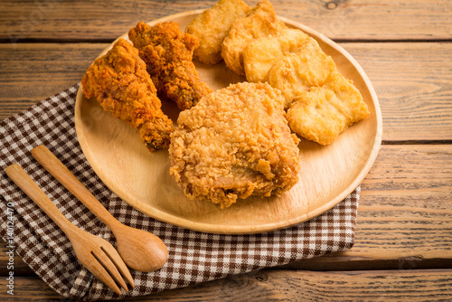 Fried chicken and nuggets on  wood table.