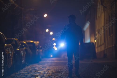 The man with a flashlight inspect the street. Evening night time © realstock1
