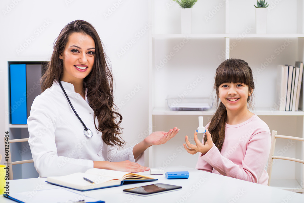 Female doctor showing how to use inhaler to a child at the medical office. Female doctor showing how to use inhaler to a child at the medical office.