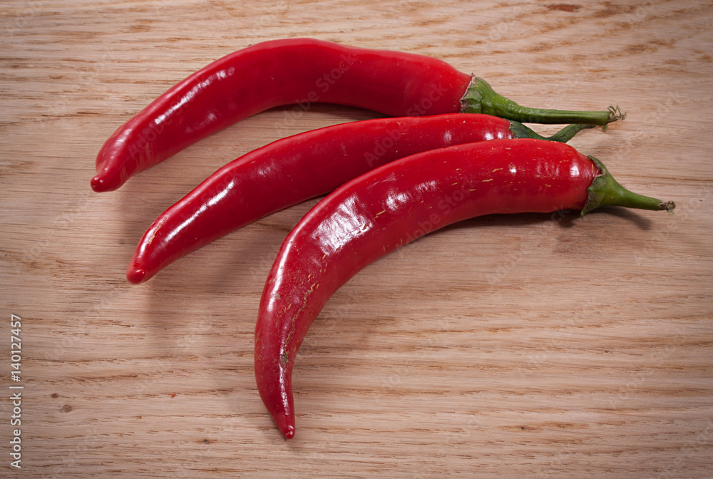 Hot red chili or chili pepper on wooden background