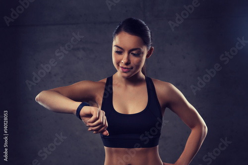 young woman with heart-rate watch in gym