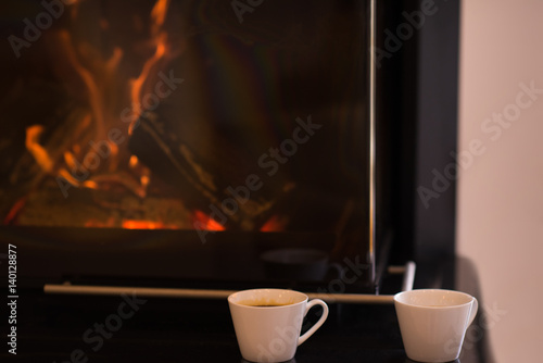 two mugs in front of fireplace