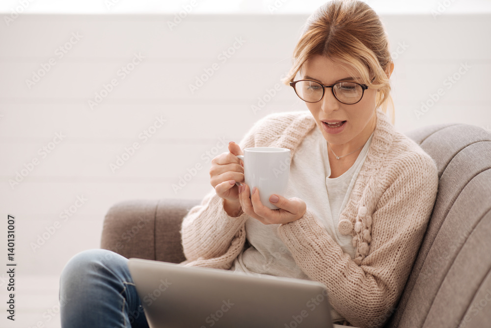 Attractive young woman looking at the laptop screen Attractive young woman looking at the laptop screen
