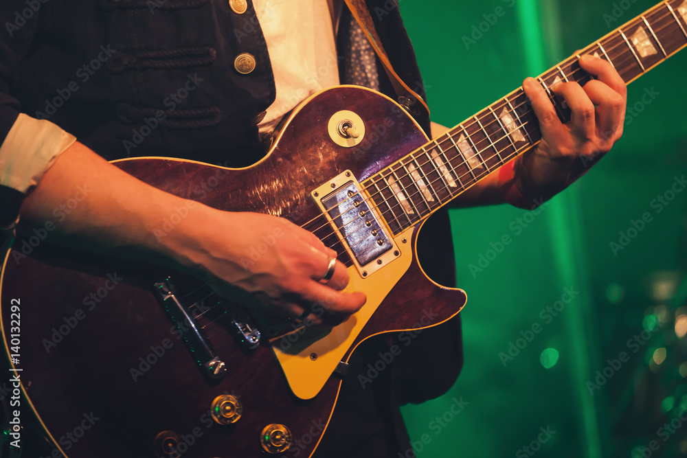Fototapeta premium Electric guitar player on a stage, soft focus