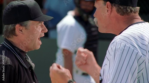Close-up profiles of a coach and an umpire having an altercation