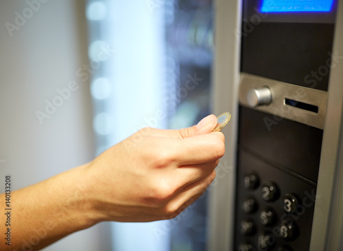 hand inserting euro coin to vending machine