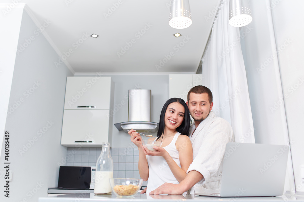 Couple having breakfast at kitchen and watching news. Couple having breakfast at kitchen and watching news.