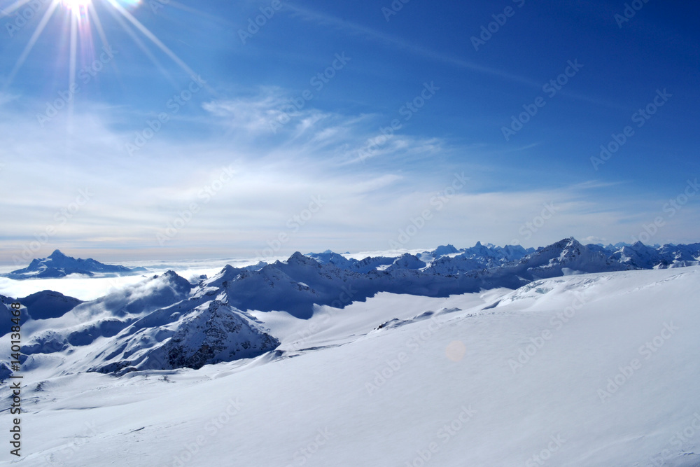 snow peaks, ridge, blue sky, floating clouds. beautiful view from ski slope.
