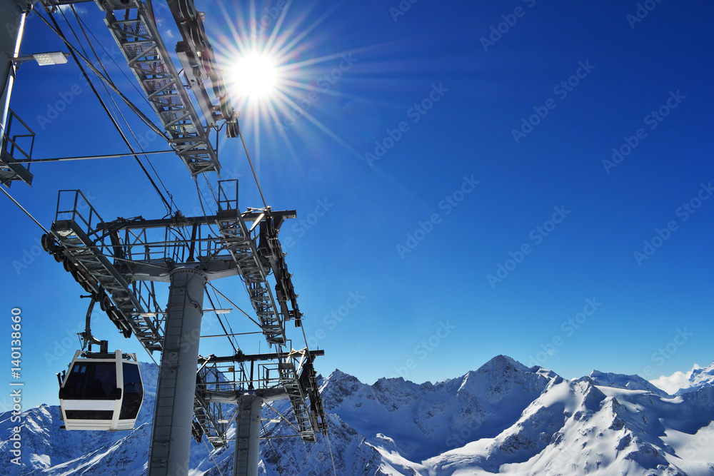 the cabin of the ski lift rises to the peak of the mountains.
