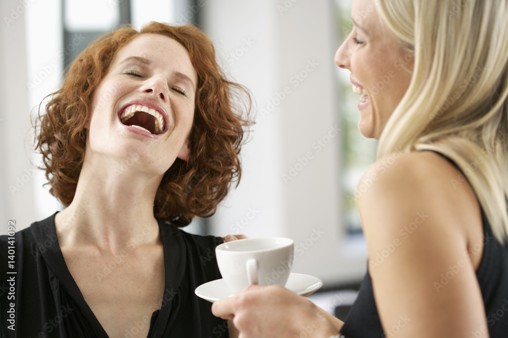Two laughing young women drinking coffee Two laughing young women drinking coffee