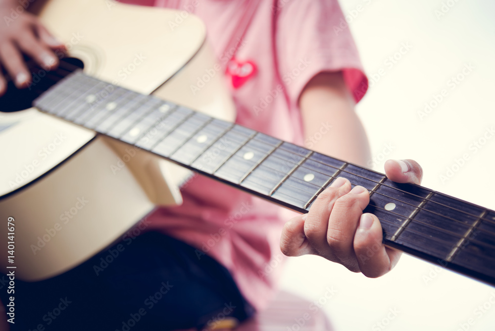 Fototapeta premium Asian boy is playing guitar on white background.