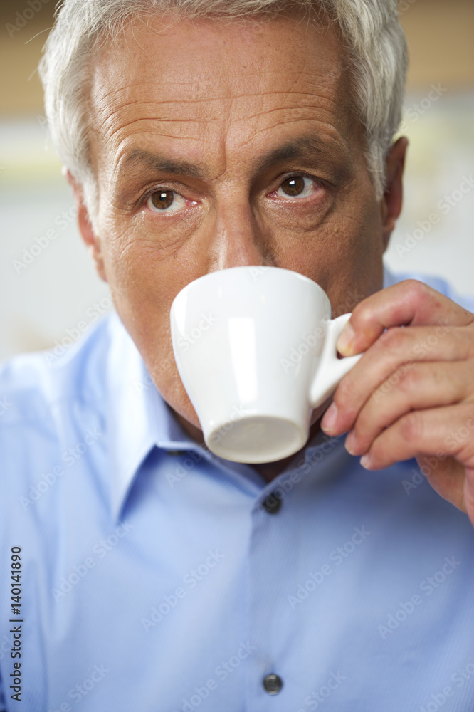 Gray-haired man drinking from a cup of coffee, close-up Gray-haired man drinking from a cup of coffee, close-up