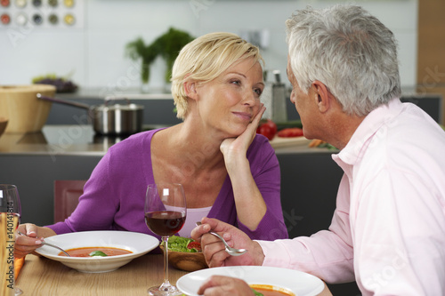 Blonde woman and gray-haired man having dinner, close-up
