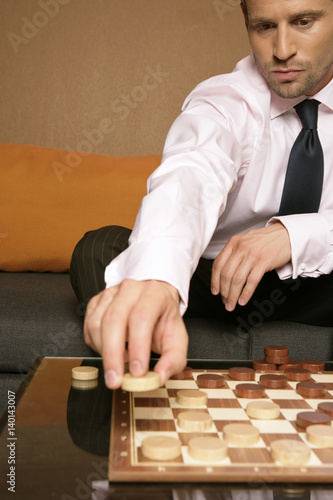 Businessman playing checkers 