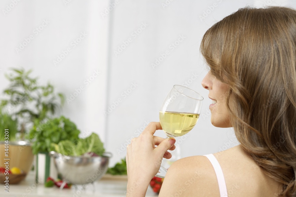 Mid adult woman drinking a glass of white wine Mid adult woman drinking a glass of white wine