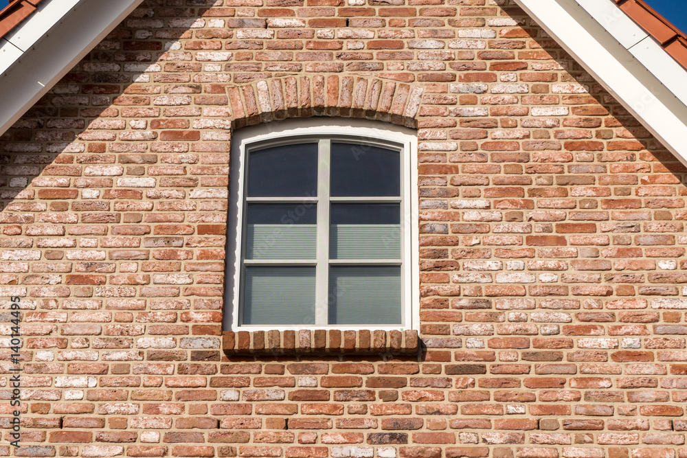 Fototapeta premium Fenster in einer Hauswand unter dem Dach