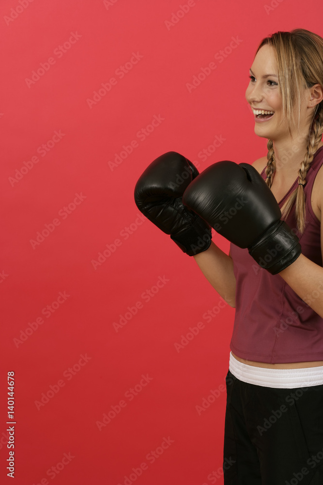 A laughing woman wearing boxing gloves