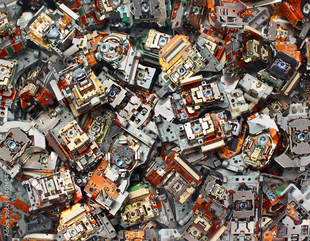 Parts of old optical drives as industrial waste background. Broken cd