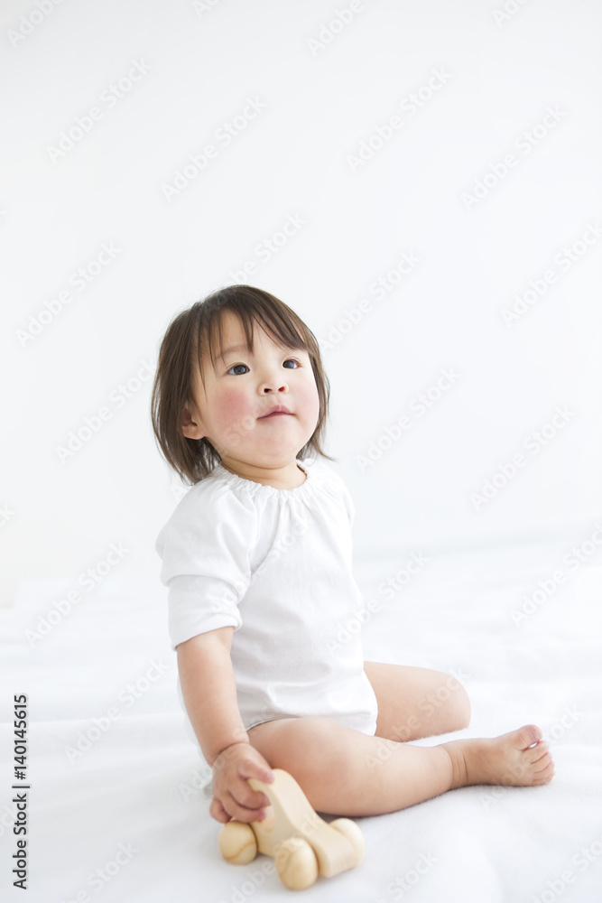 Baby girl playing with wooden toy car Baby girl playing with wooden toy car