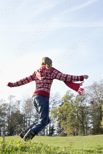 Young woman running happily over a meadow