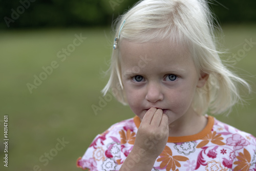 Little girl with her hand on her mouth, selective focus