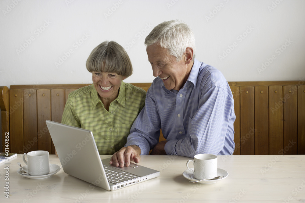 Senior adult couple sitting in front of a laptop Senior adult couple sitting in front of a laptop