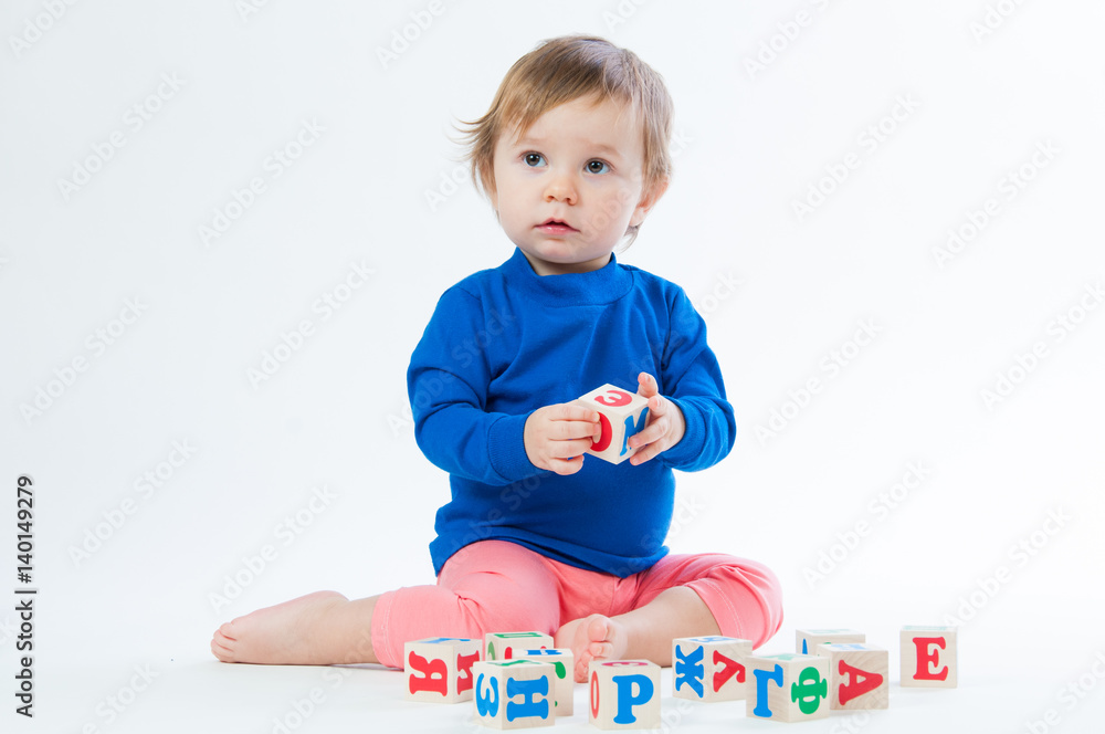 Little child playing with dices isolated on white background Little child playing with dices isolated on white background