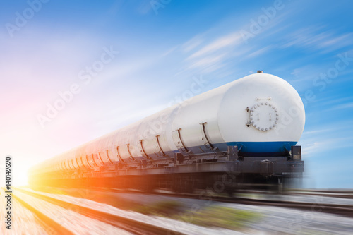Tanks with gas being transported by rail at sunset