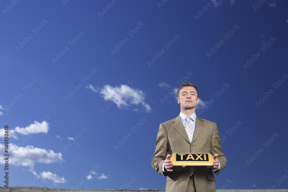 Businessman holding a taxi sign Businessman holding a taxi sign