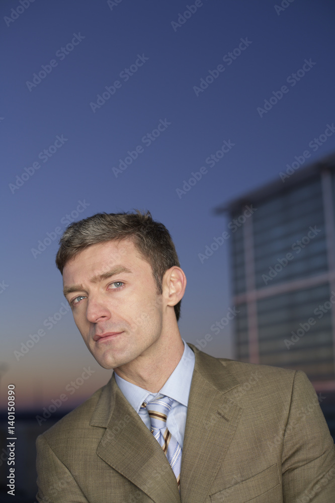 Businessman looking at camera in twilight
