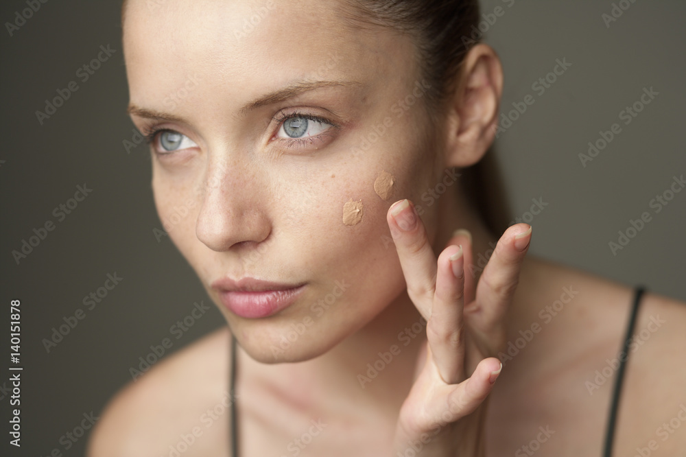 Young woman putting on makeup, close-up Young woman putting on makeup, close-up