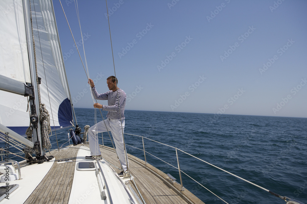 Naklejka premium Man working on a sailing yacht