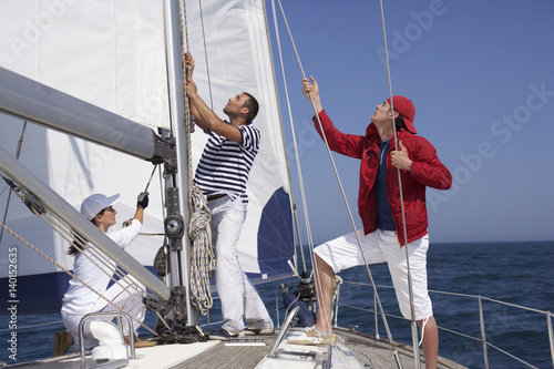 Three people working on a yacht