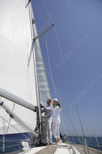 Two people working on a sailing yacht