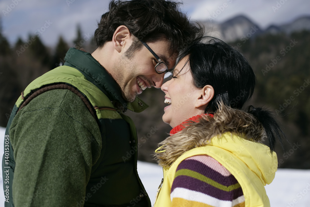 Fototapeta premium Young couple standing face to face, laughing