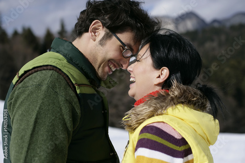 Young couple standing face to face, laughing