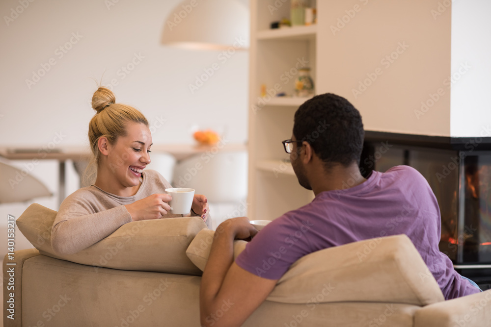 Young multiethnic couple in front of fireplace Young multiethnic couple in front of fireplace
