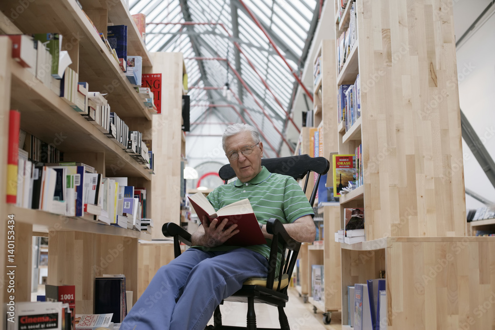 Senior man in a rocking chair reading a book, fully_released Senior man in a rocking chair reading a book, fully_released