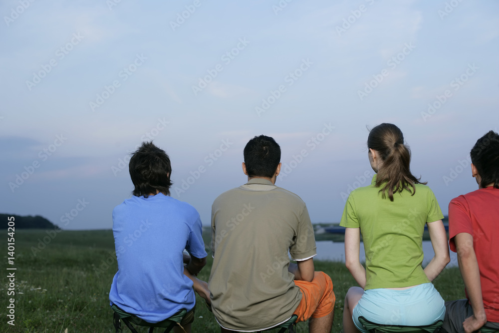 Four young people sitting in a line