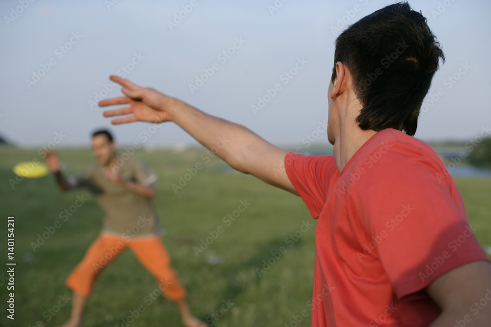 Two young men playing with a frisbee Two young men playing with a frisbee